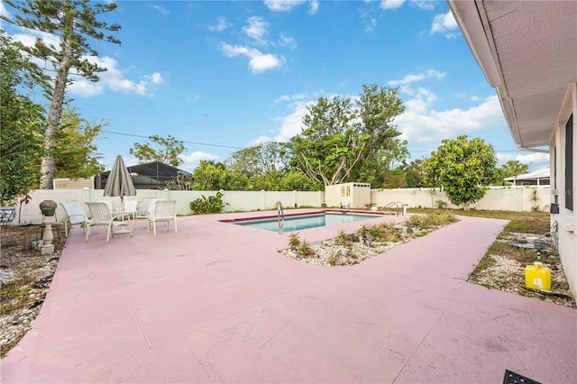 view of pool featuring a fenced in pool, an outdoor structure, a patio area, a fenced backyard, and a storage unit