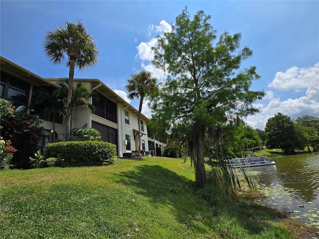 view of green lawn with a water view