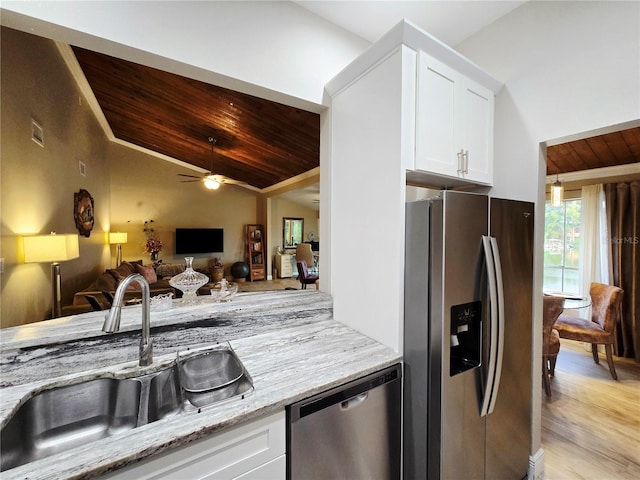 kitchen with stainless steel appliances, a sink, lofted ceiling, wooden ceiling, and light stone countertops