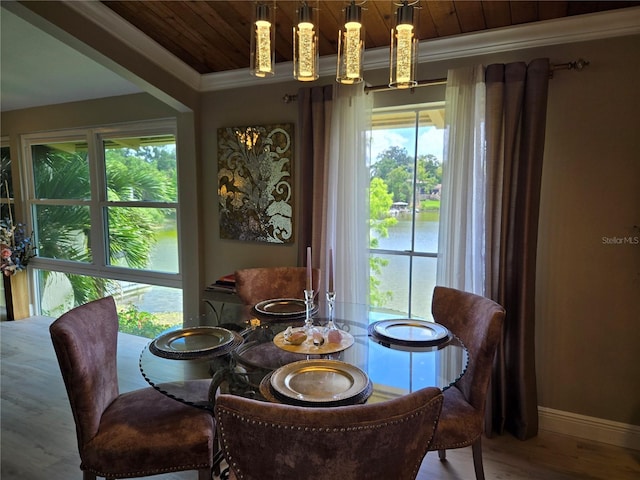dining room featuring wood ceiling, crown molding, healthy amount of natural light, wood finished floors, and baseboards