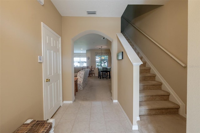4103 Foristall Ave Unit 4103, Sarasota, FL 34233 - stairway with arched walkways, carpet floors, tile patterned flooring, baseboards, and a chandelier