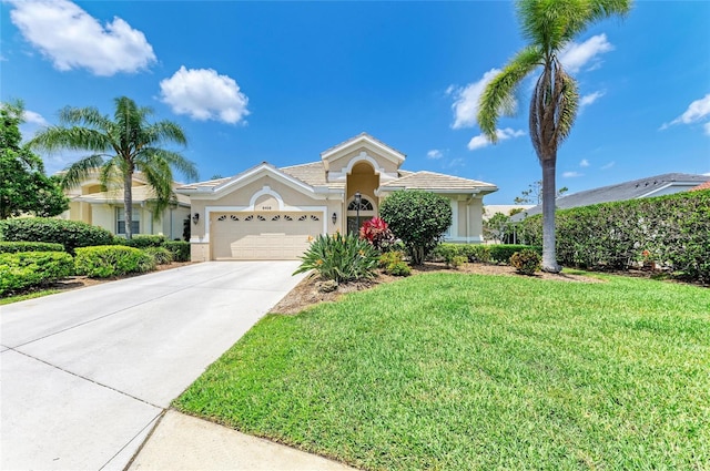 8408 Whispering Woods Ct, Lakewood Ranch, FL 34202 - view of front of home with stucco siding, an attached garage, a front yard, and concrete driveway