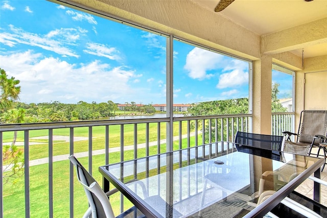 sunroom / solarium featuring outdoor dining area and a water view