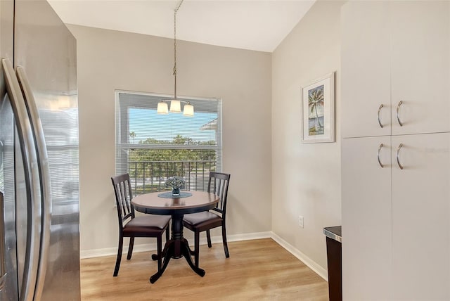 dining room with light wood finished floors, baseboards, and a chandelier