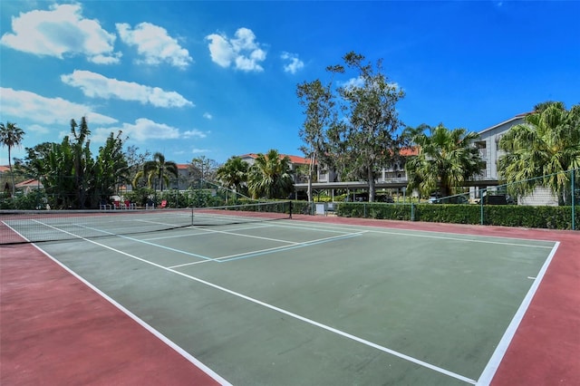 view of tennis court with community basketball court and fence