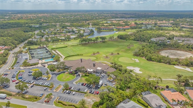 aerial view of property's location featuring a local golf course, a nearby body of water, and nearby suburban area
