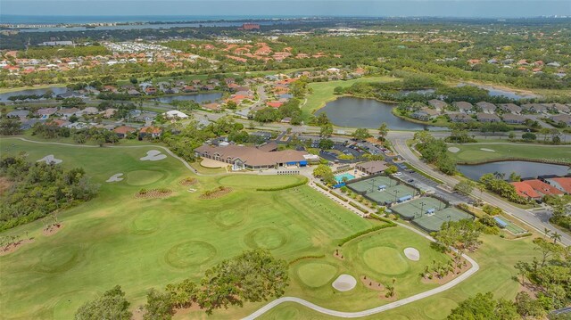 view of property location with a nearby body of water, nearby suburban area, and a golf course