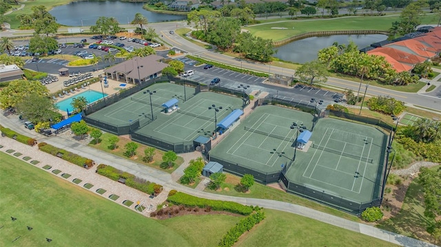 drone / aerial view of a large body of water, a pool, and a local golf course