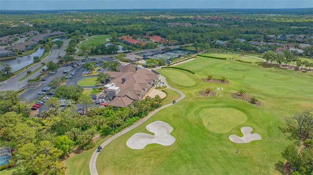 view of property location featuring a local golf course and a nearby body of water