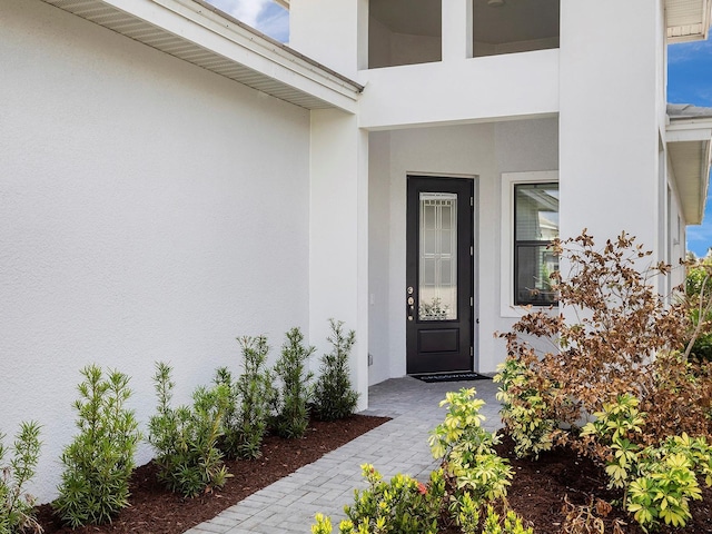 doorway to property featuring stucco siding