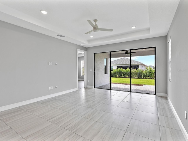 empty room featuring a tray ceiling, a ceiling fan, baseboards, light tile patterned flooring, and recessed lighting