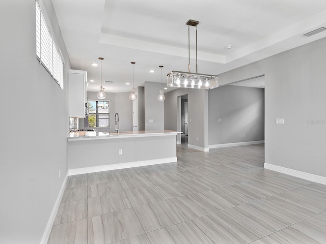 unfurnished living room with baseboards, a tray ceiling, and recessed lighting