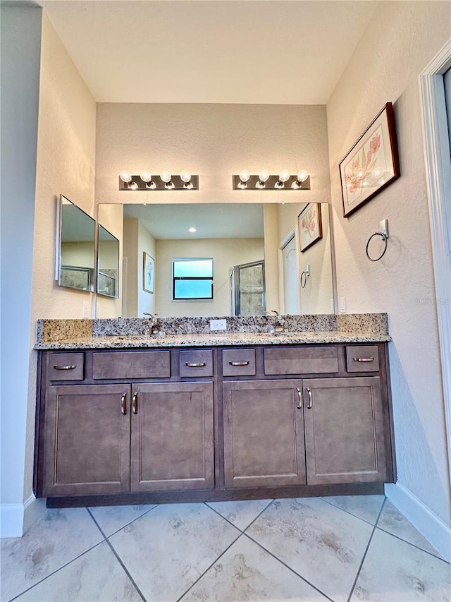 1568 Cordgrass Way, Lakeland, FL 33813 - bathroom featuring double vanity, a textured wall, a shower with shower door, and tile patterned flooring