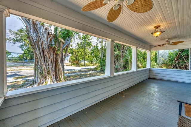 unfurnished sunroom with a ceiling fan, wooden ceiling, and hardwood / wood-style flooring