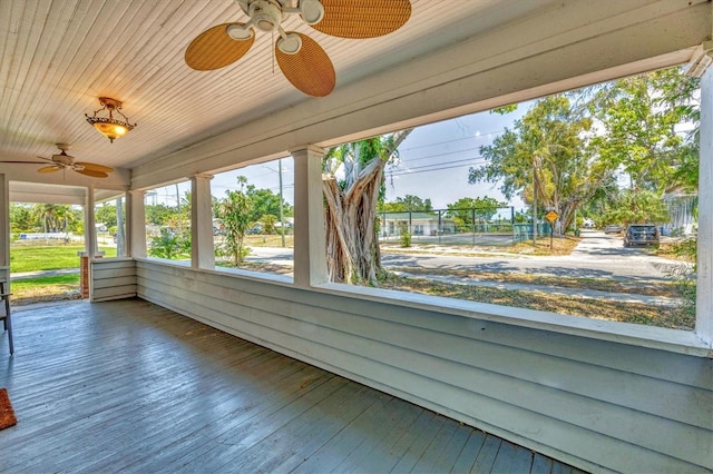 unfurnished sunroom featuring a ceiling fan, wood ceiling, and hardwood / wood-style flooring