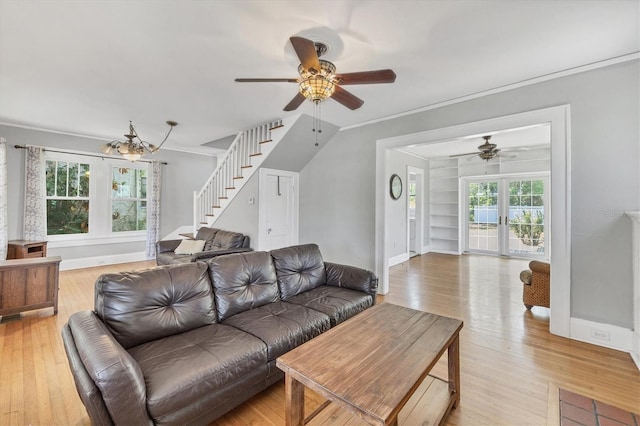 living room with a ceiling fan, stairway, ornamental molding, and light wood-type flooring