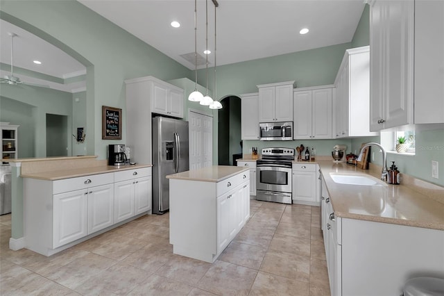 1542 Ormond Ter, Parrish, FL 34219 - kitchen featuring stainless steel appliances, a sink, arched walkways, a center island, and light countertops