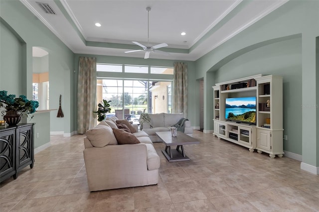 1542 Ormond Ter, Parrish, FL 34219 - living room with ceiling fan, a tray ceiling, crown molding, light tile patterned flooring, and baseboards