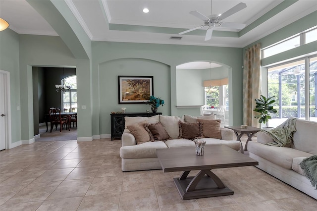 1542 Ormond Ter, Parrish, FL 34219 - living room featuring a tray ceiling, a chandelier, arched walkways, ornamental molding, and ceiling fan