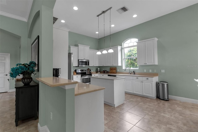 1542 Ormond Ter, Parrish, FL 34219 - kitchen featuring appliances with stainless steel finishes, a sink, a kitchen island, white cabinets, and a peninsula