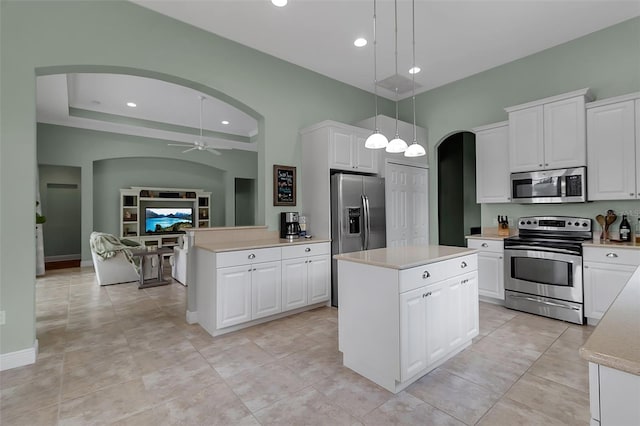 1542 Ormond Ter, Parrish, FL 34219 - kitchen featuring stainless steel appliances, arched walkways, ceiling fan, light countertops, and a kitchen island