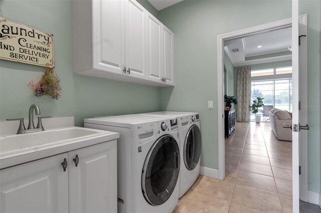 1542 Ormond Ter, Parrish, FL 34219 - laundry area with cabinet space, washer and dryer, light tile patterned flooring, and baseboards