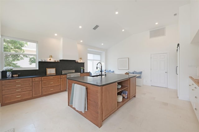 kitchen featuring brown cabinetry, open shelves, a sink, plenty of natural light, and recessed lighting