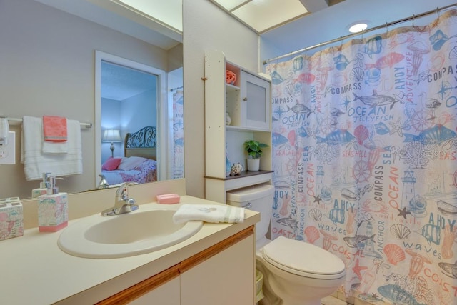ensuite bathroom featuring toilet, vanity, and curtained shower