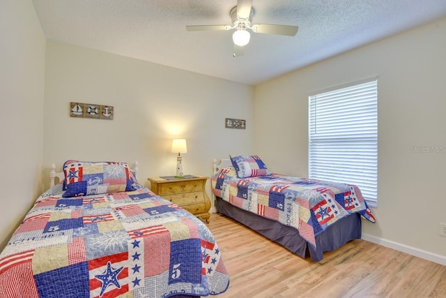 bedroom featuring wood finished floors, a ceiling fan, and baseboards