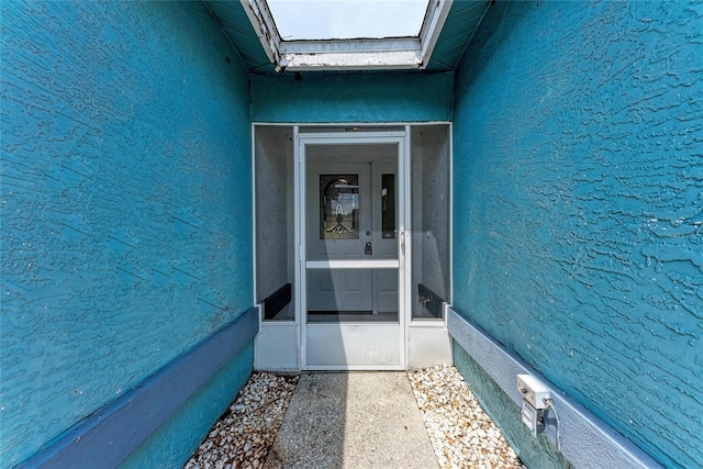 doorway to property featuring stucco siding