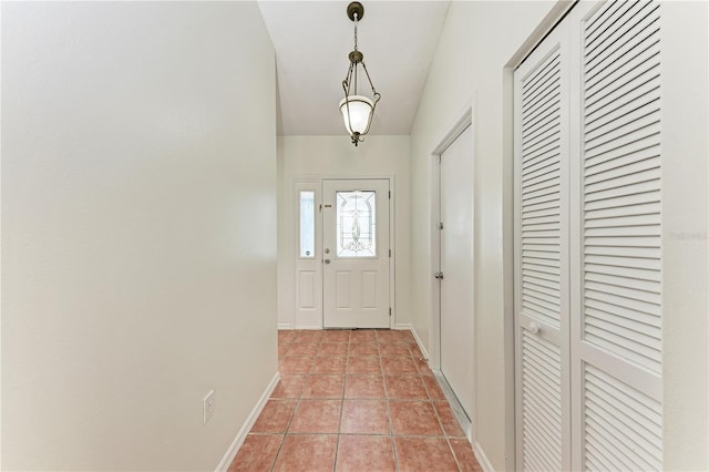doorway to outside featuring light tile patterned floors and baseboards