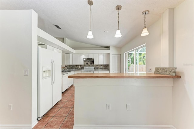 kitchen with white appliances, lofted ceiling, wood counters, a peninsula, and tile patterned floors