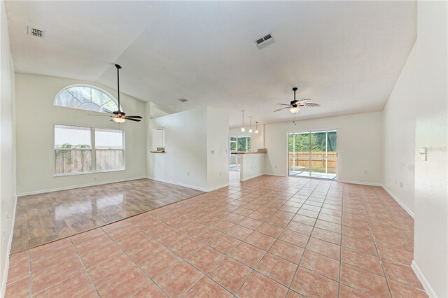spare room with ceiling fan, vaulted ceiling, and baseboards
