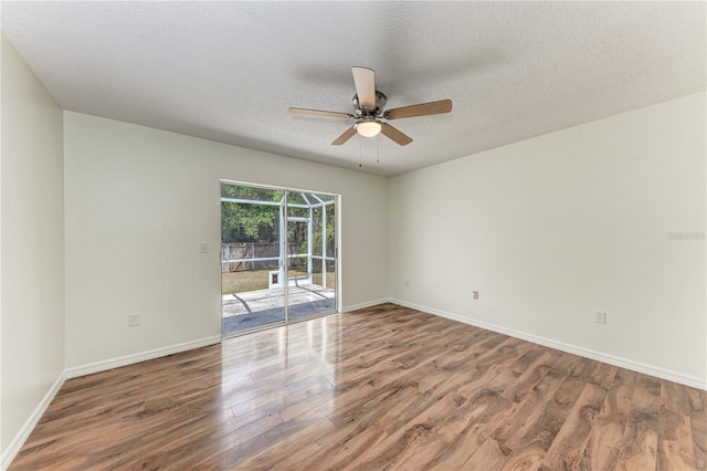 unfurnished room with wood finished floors, a ceiling fan, baseboards, and a textured ceiling
