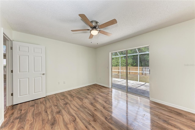 spare room featuring wood finished floors, ceiling fan, a textured ceiling, and baseboards