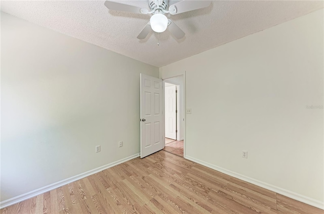 empty room featuring light wood finished floors, baseboards, a textured ceiling, and ceiling fan