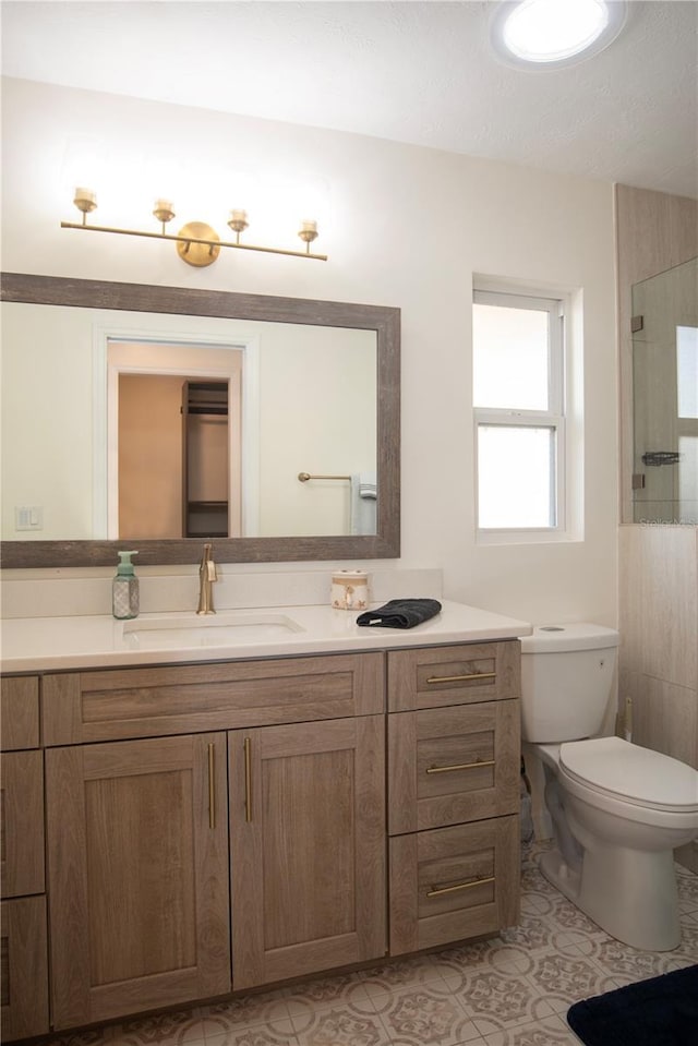 bathroom featuring an enclosed shower, toilet, vanity, and tile patterned flooring