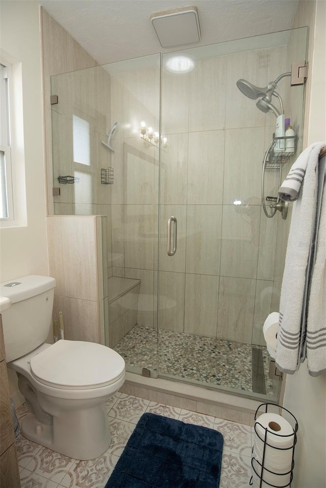 full bathroom featuring tile patterned flooring, toilet, and a stall shower