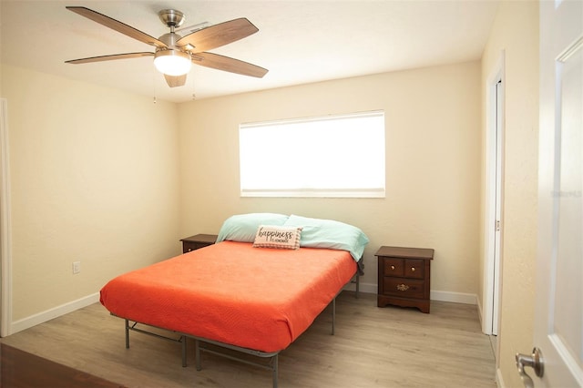 bedroom featuring light wood-style flooring, baseboards, and a ceiling fan