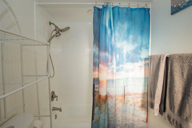 bathroom featuring shower / bath combo and toilet