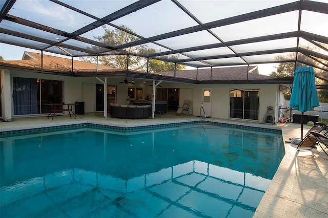 swimming pool with ceiling fan, an outdoor hangout area, a patio, and glass enclosure