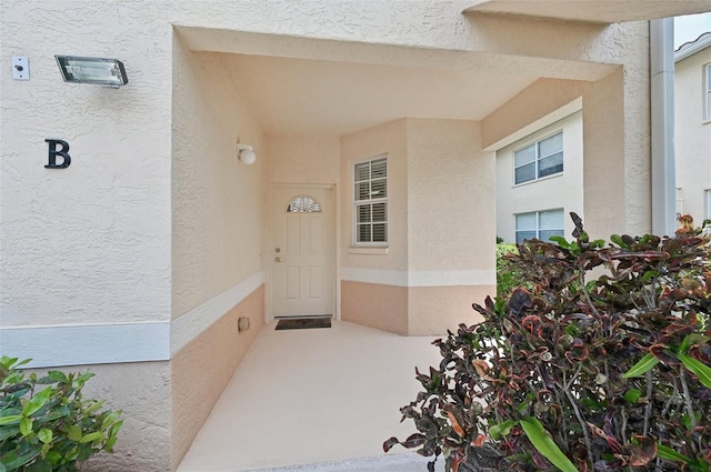 entrance to property featuring stucco siding