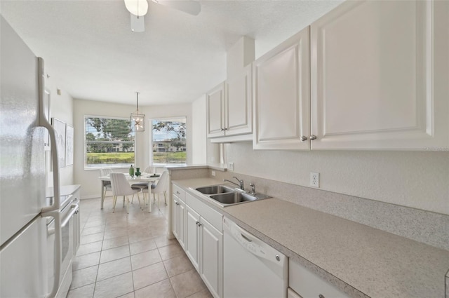 kitchen featuring white appliances, a sink, light countertops, light tile patterned flooring, and white cabinets