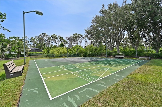 view of home's community with shuffleboard and a yard