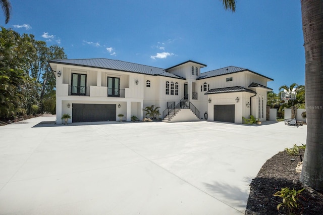 view of front of property with a standing seam roof, a garage, metal roof, and french doors