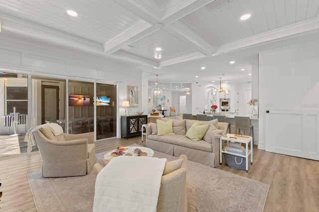 living room with a chandelier, crown molding, a decorative wall, beam ceiling, and wood finished floors