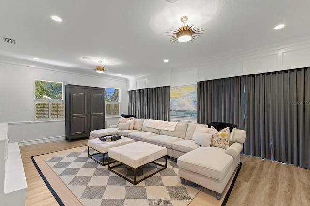 living room featuring ornamental molding, light wood finished floors, and recessed lighting