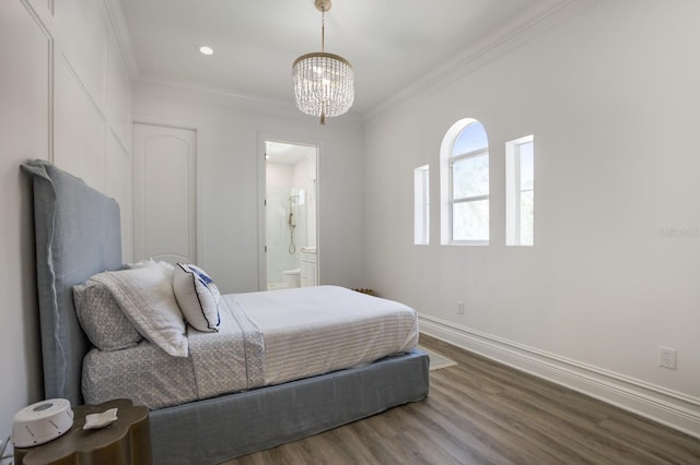 bedroom featuring crown molding, a chandelier, baseboards, wood finished floors, and ensuite bathroom
