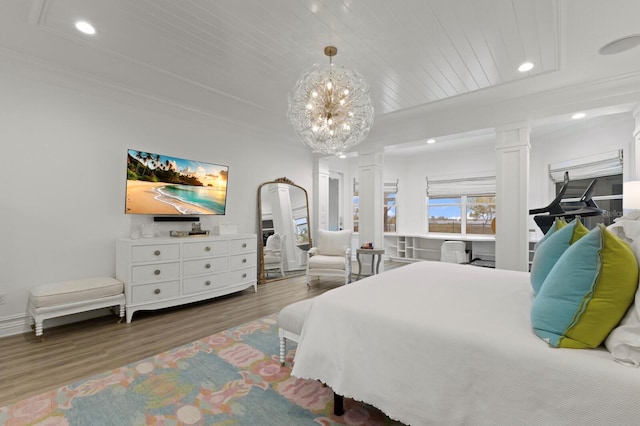 bedroom featuring decorative columns, wood finished floors, crown molding, recessed lighting, and a chandelier
