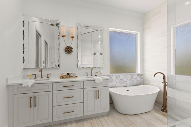 full bathroom featuring tile walls, a freestanding tub, double vanity, and ornamental molding